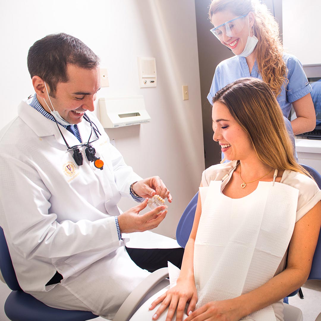 A dental hygienist assisting a patient during a teeth cleaning appointment.